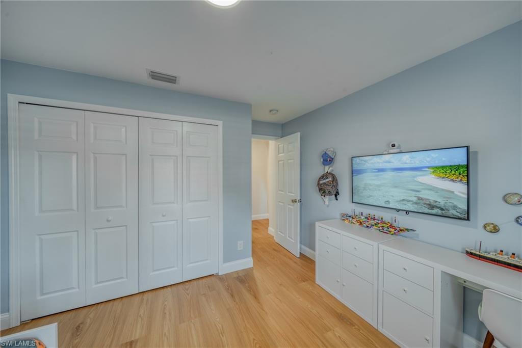 Bedroom with light wood-style flooring and a closet