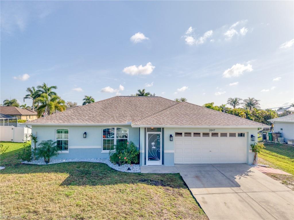 Ranch-style home with stucco siding, concrete driveway, an attached garage, and roof with shingles