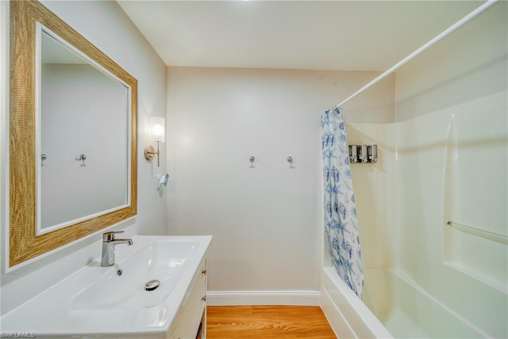 Full bath featuring vanity, light wood-style floors, and shower / tub combo