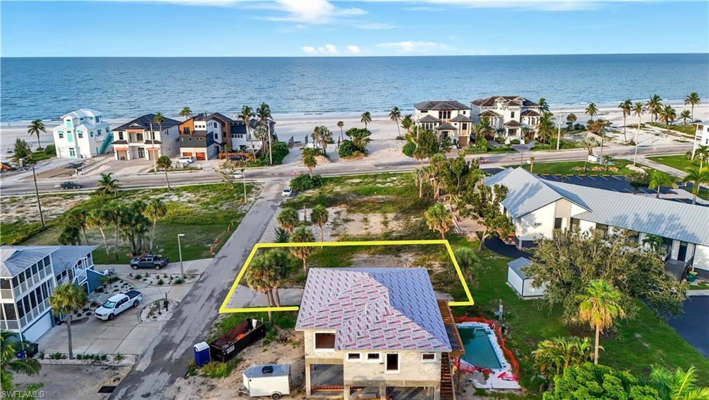 Aerial view of residential area featuring extended coastline and property boundaries highlighted - Virtually Edited Image