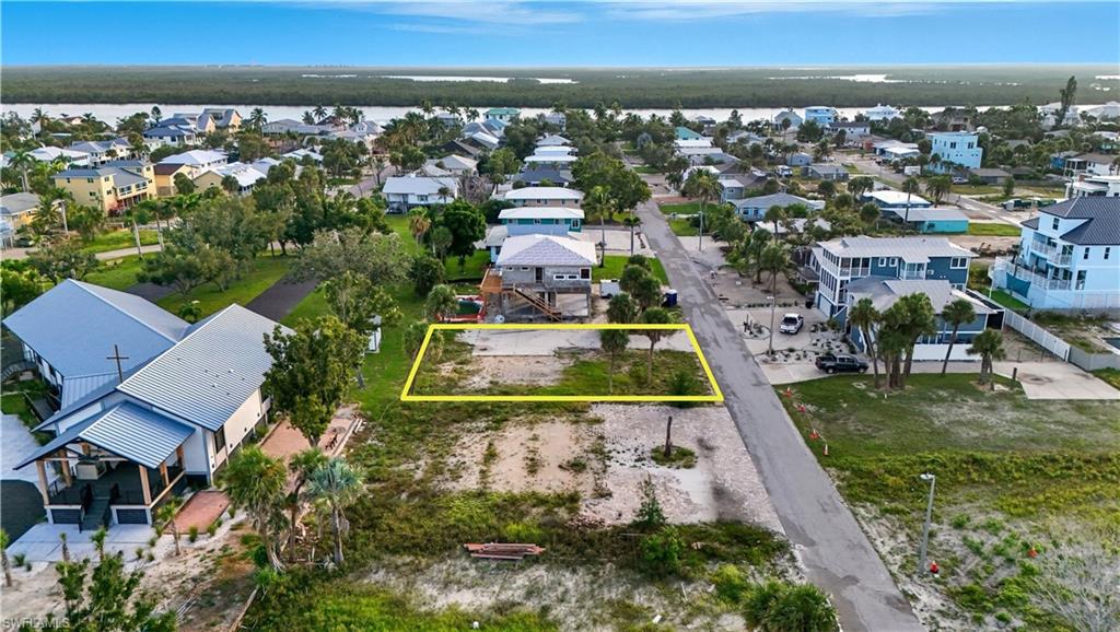 Aerial perspective of suburban area with property boundaries highlighted and a large body of water - Virtually Edited Image