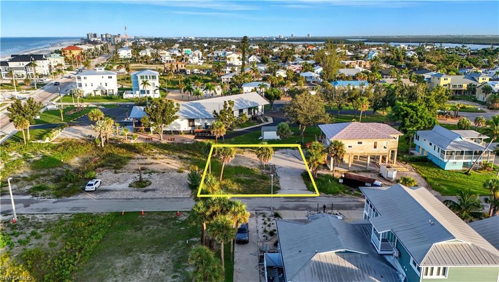Aerial view of residential area with property parcel outlined and a nearby body of water - Virtually Edited Image