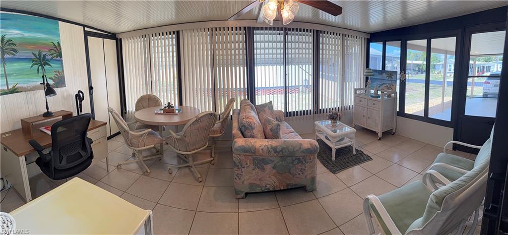 Enclosed four season lanai featuring light-colored tile flooring and access to utility room.