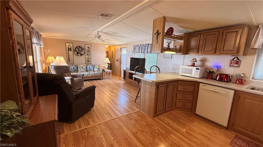 Open-concept living area featuring wood-look flooring and vaulted ceiling.