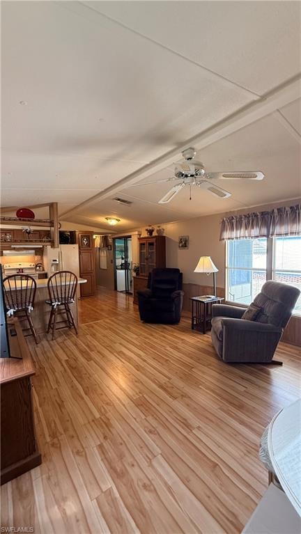 Open-concept living space featuring wood-look flooring and vaulted ceiling throughout.