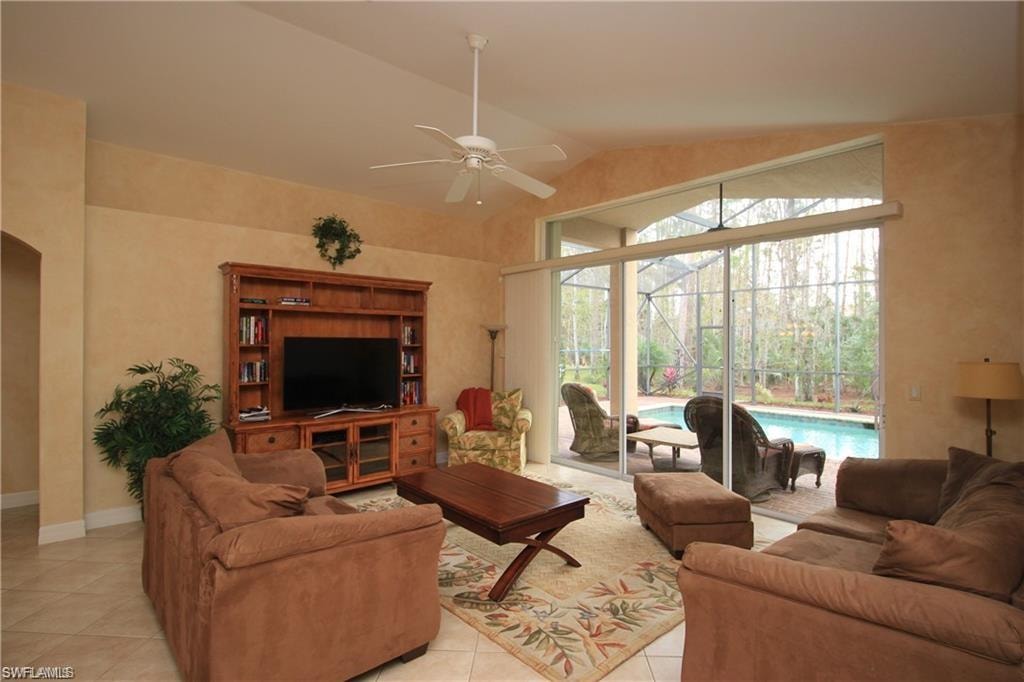 Tiled living room featuring vaulted ceiling and ceiling fan