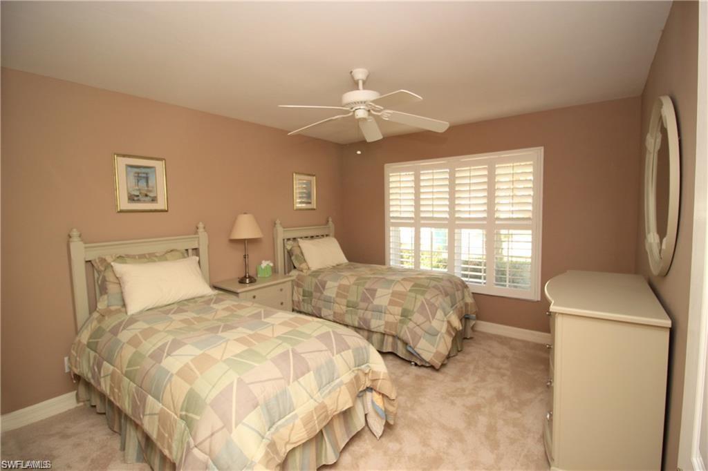 Carpeted bedroom featuring ceiling fan