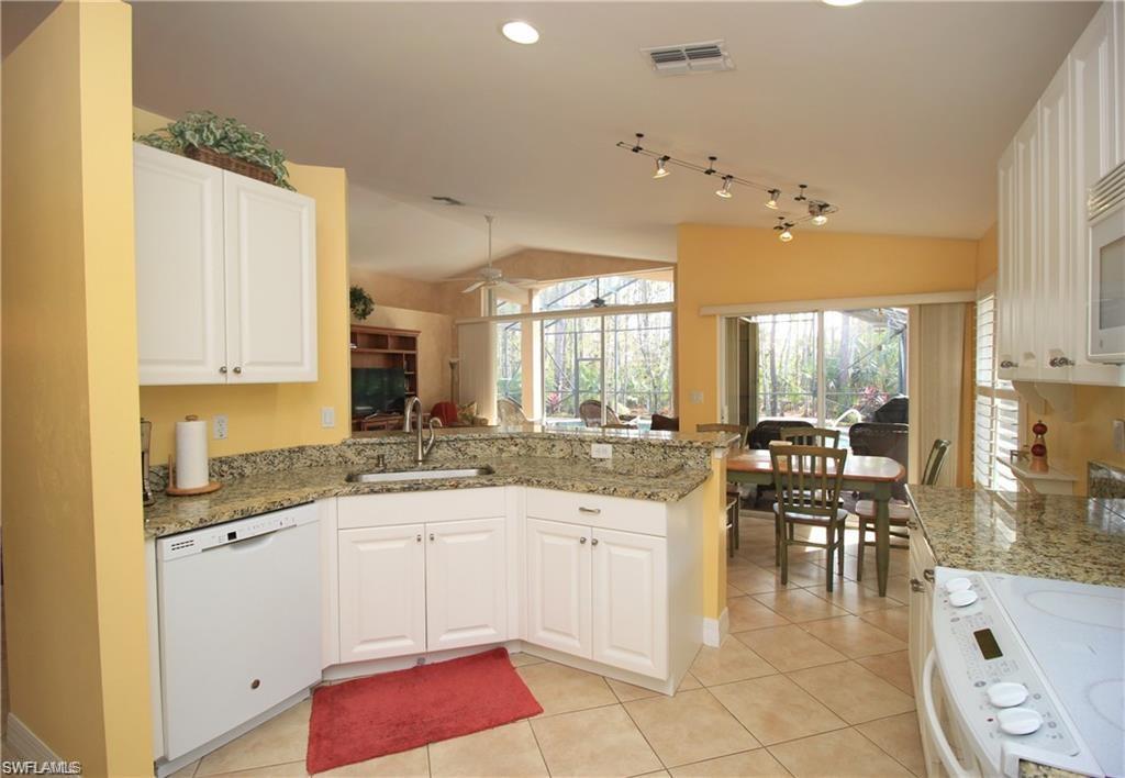 Kitchen featuring white cabinets, white appliances, kitchen peninsula, and ceiling fan