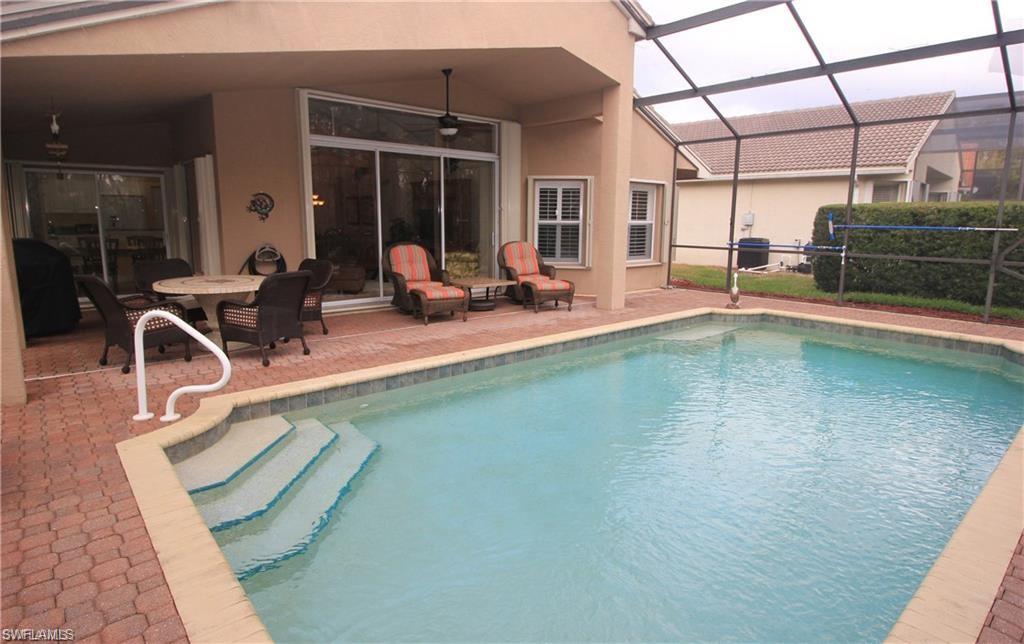 View of pool with a lanai, ceiling fan, and a patio