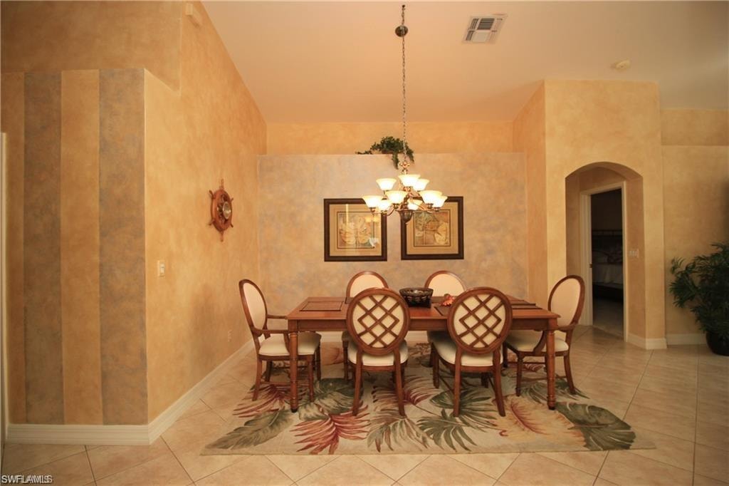 Tiled dining room featuring a notable chandelier