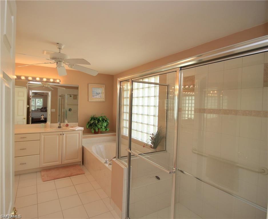 Bathroom featuring vanity, separate shower and tub, ceiling fan, and tile patterned floors