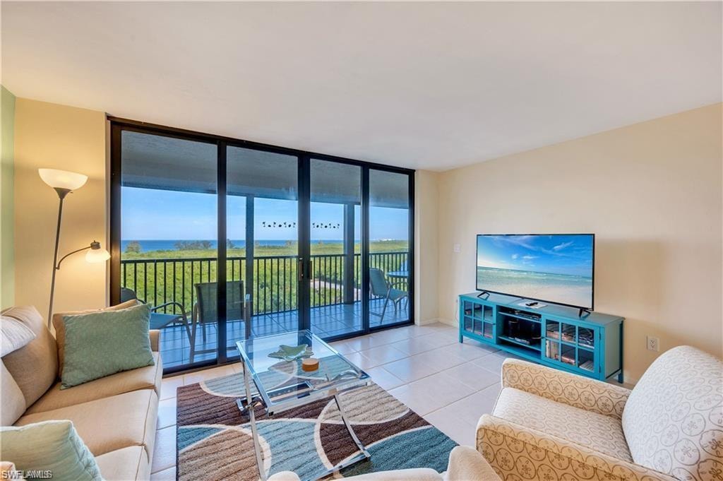 Living room with tile patterned flooring and floor to ceiling windows