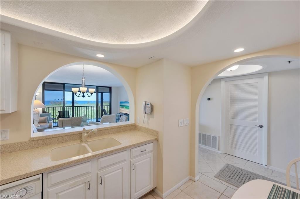 Bathroom featuring vanity, an inviting chandelier, and tile patterned flooring