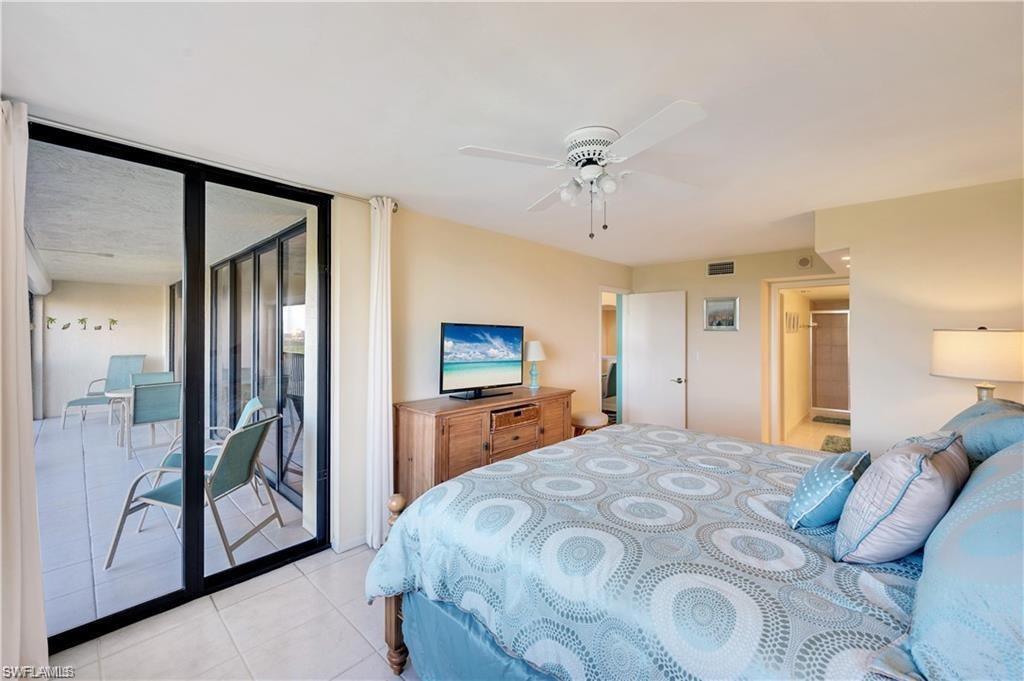 Bedroom with ensuite bath, access to exterior, light tile patterned floors, and ceiling fan
