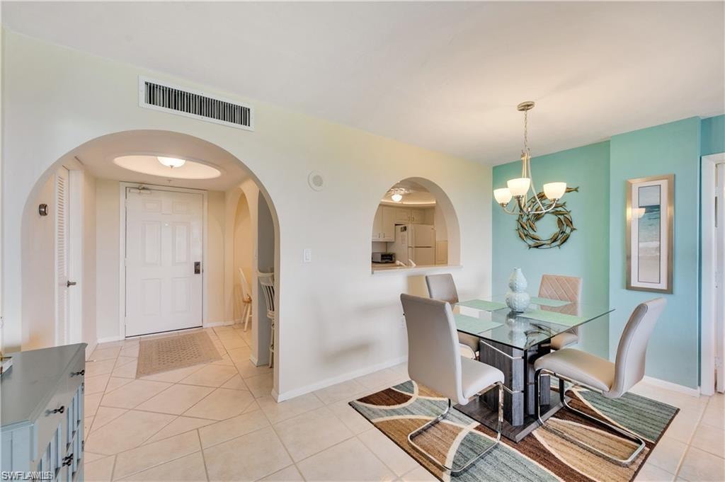 Tiled dining room with a chandelier