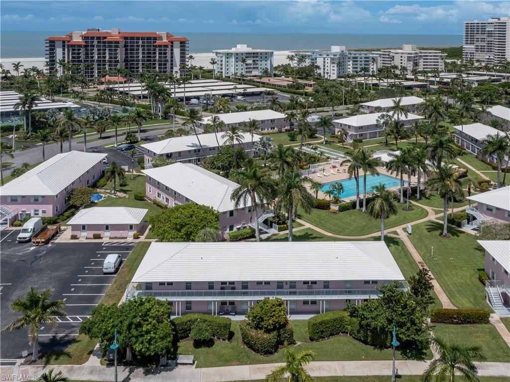 Aerial perspective showcasing multi-story residential buildings with white roofs and pink exteriors