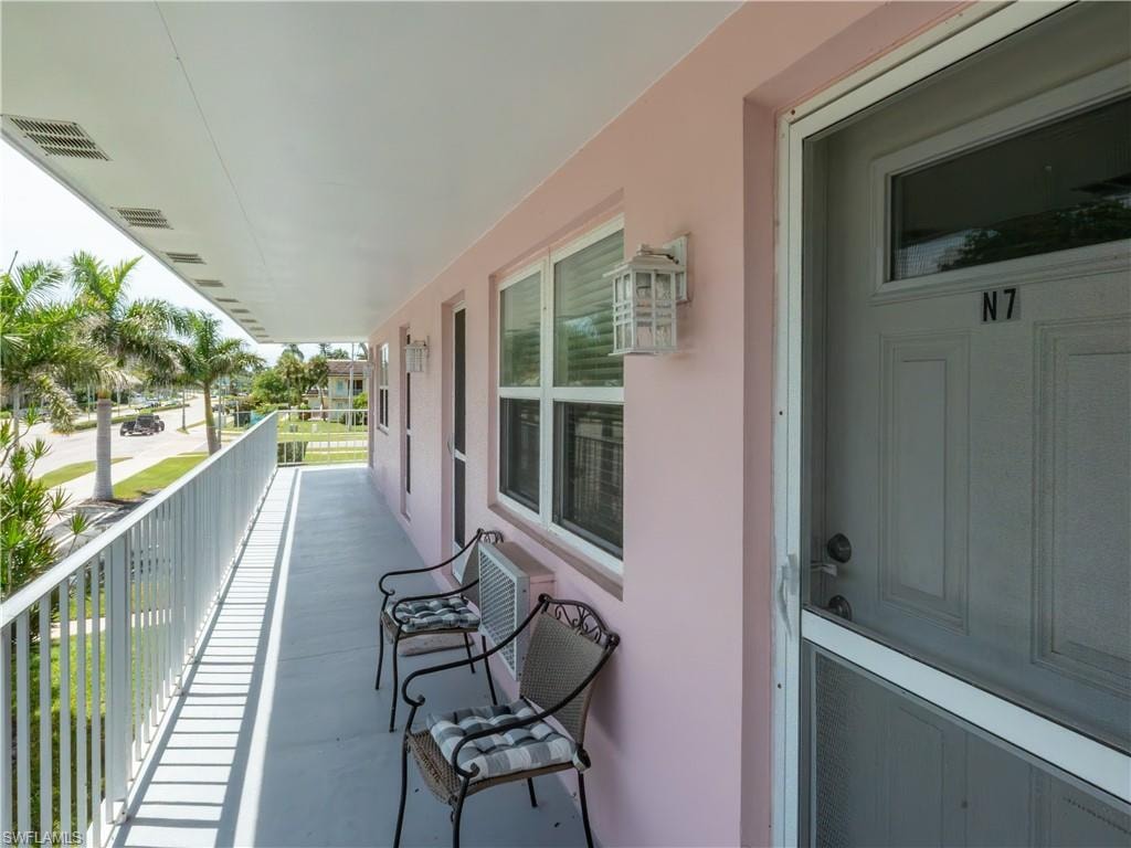 Covered exterior balcony with pale pink stucco facade