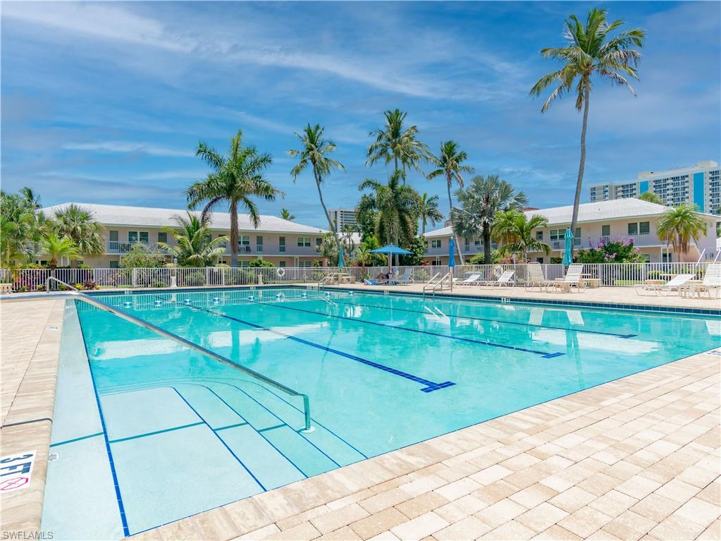 Expansive outdoor swimming pool with lane markers, integrated steps, and stainless steel handrails