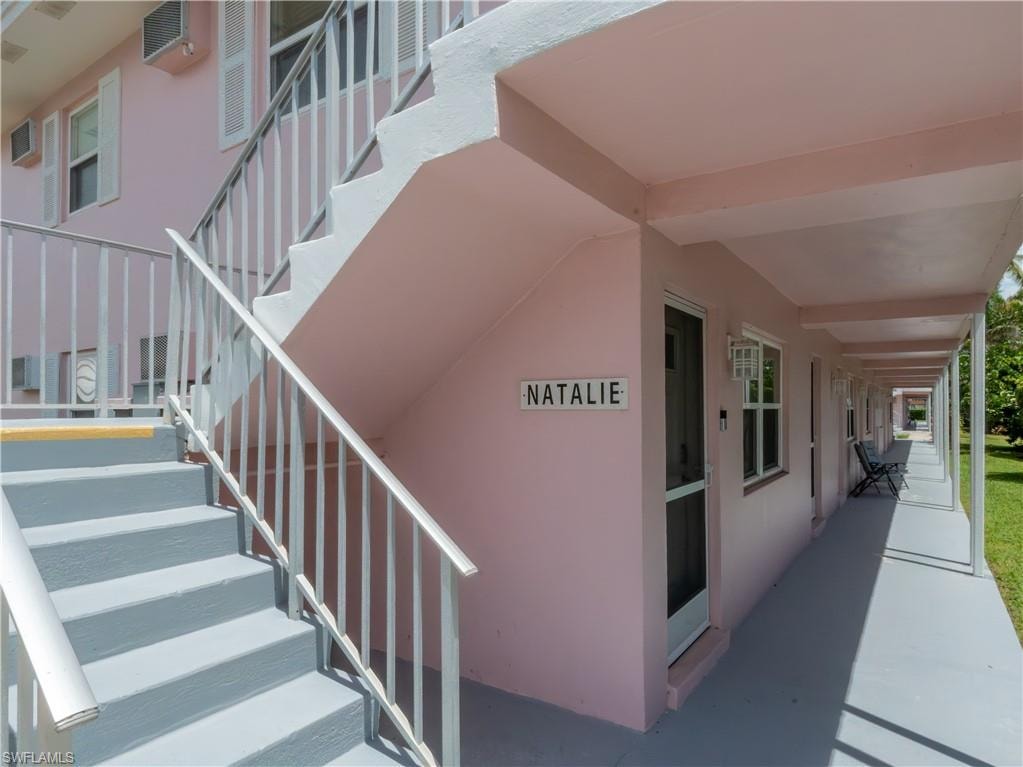 Exterior building featuring a pastel pink facade and covered walkways