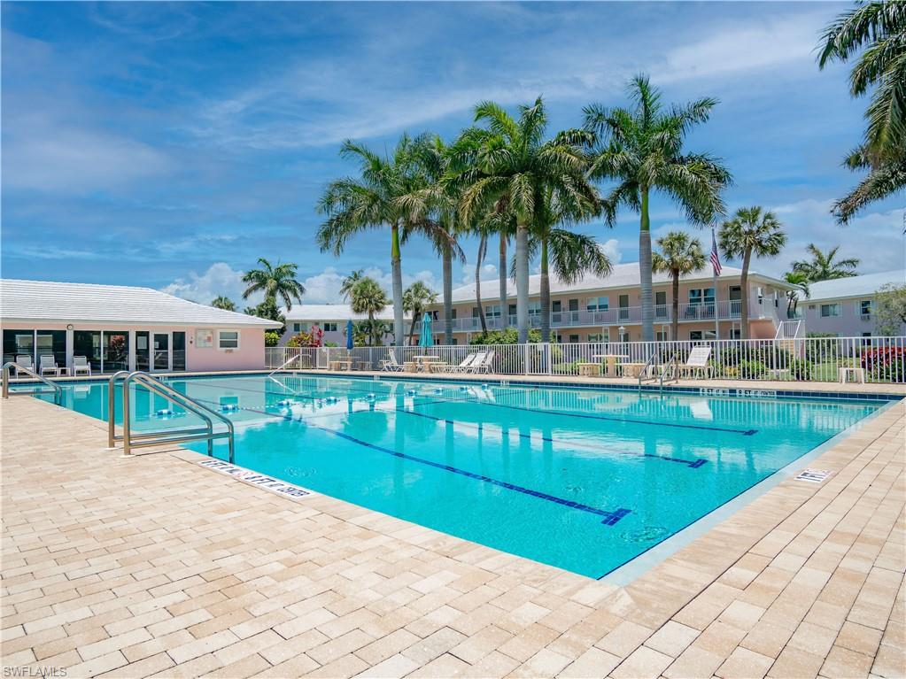 Outdoor swimming pool with lane markers, surrounded by light-toned paver decking