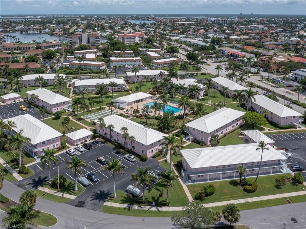 Aerial perspective showcasing a residential community with multiple two-story buildings featuring white roofs and light pink facades