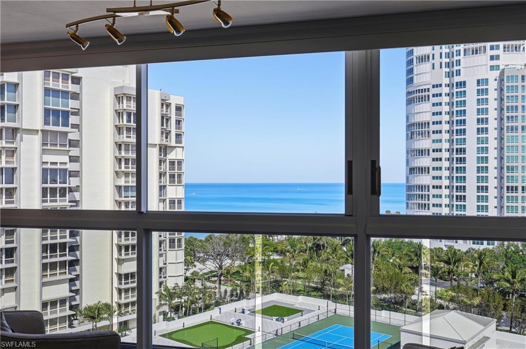 Expansive window offering broad ocean, building, and amenity court views