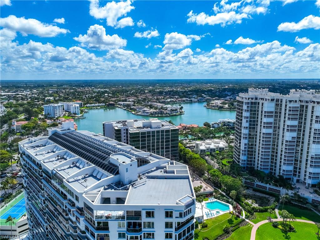 Expansive aerial showcasing multiple high-rise buildings, a large body of water, and surrounding residential areas