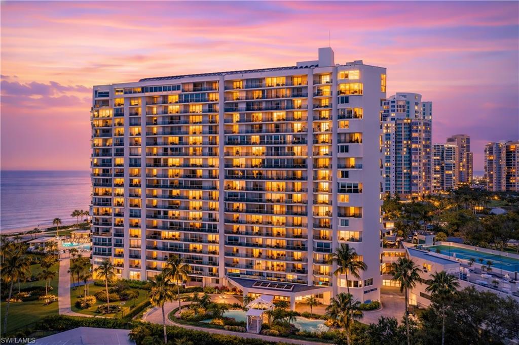 High-rise building featuring extensive private balconies, a multi-story design, and illuminated interiors