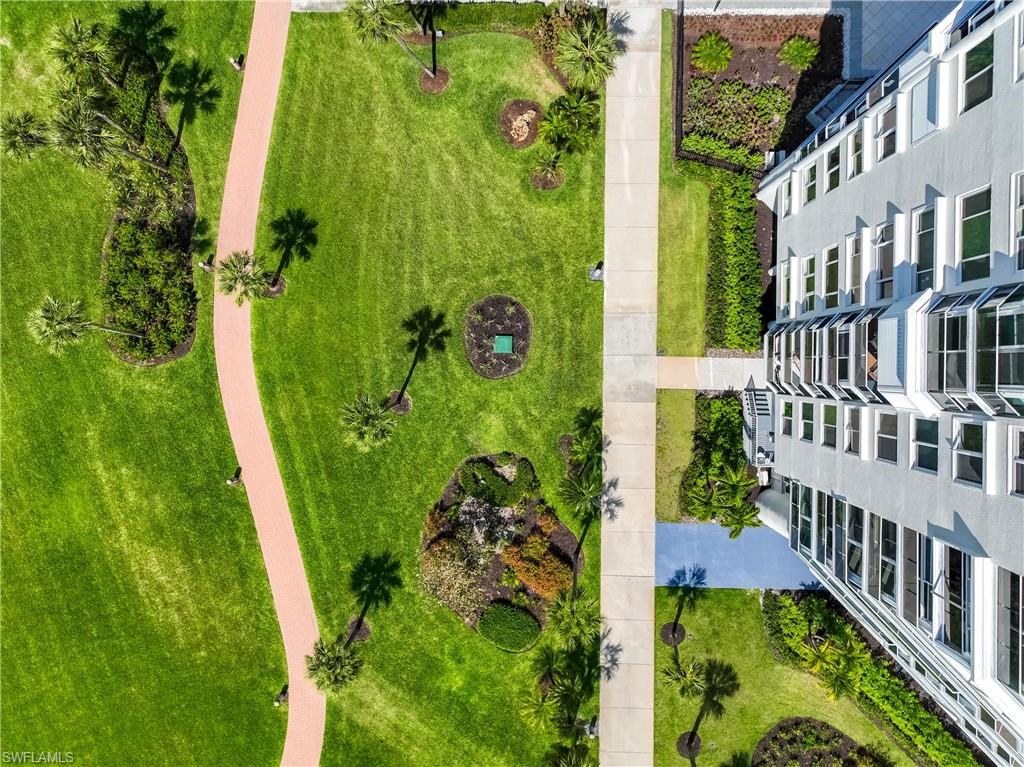 Expansive green spaces featuring a winding pedestrian path, mature palm trees, and varied shrubbery
