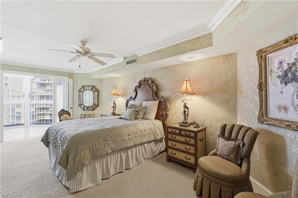 Carpeted bedroom featuring a coffered ceiling with crown molding, textured wall finishes, and sliding glass doors