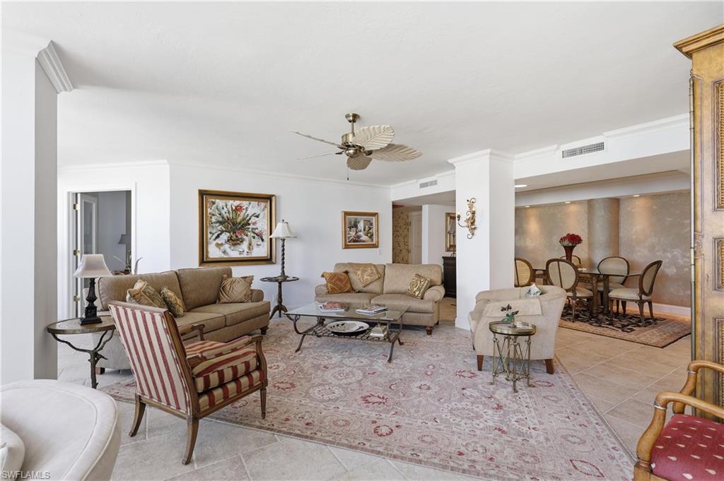 Spacious common area featuring tiled flooring, crown molding, and a ceiling fan