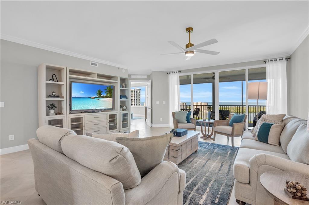 Living room featuring ornamental molding and ceiling fan