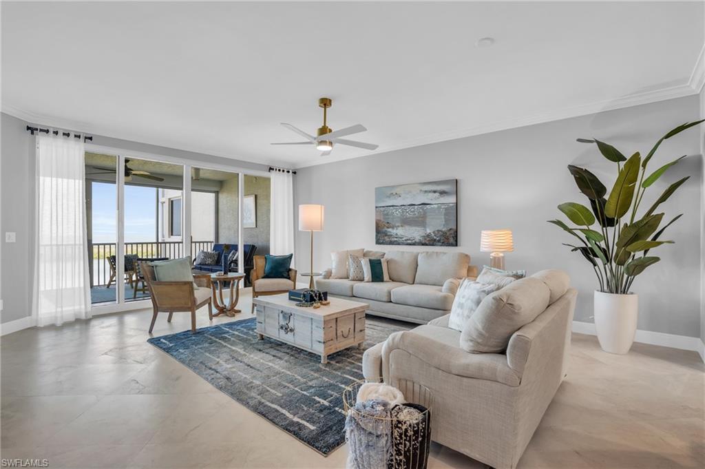 Living room featuring ornamental molding, ceiling fan, and light tile floors