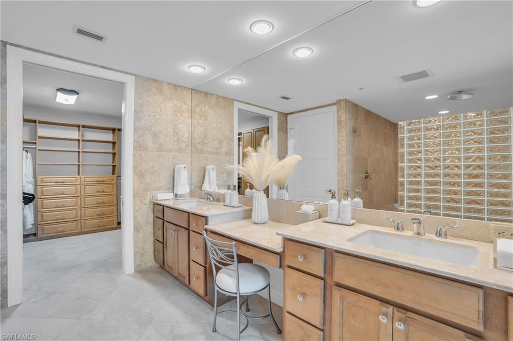 Bathroom with tile flooring, tile walls, and vanity