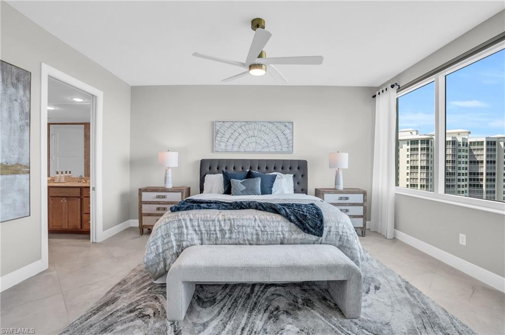 Bedroom with ensuite bathroom, ceiling fan, and light tile floors