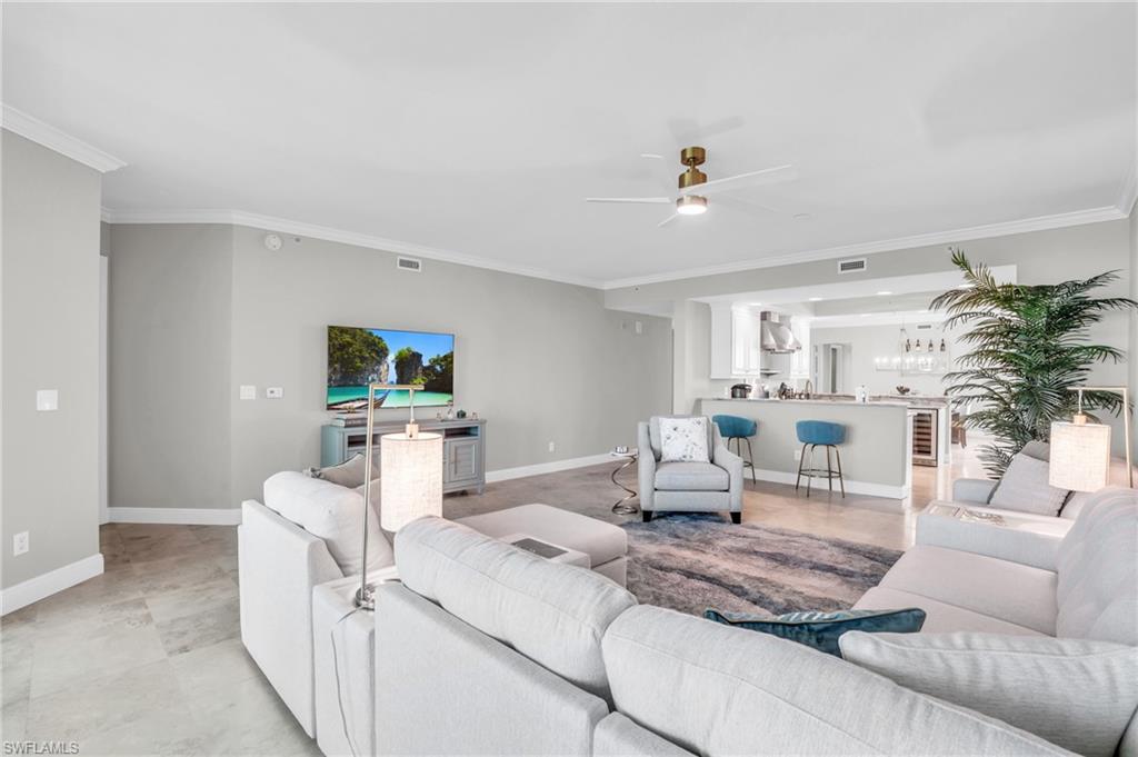 Living room featuring crown molding, ceiling fan, and light tile patterned floors