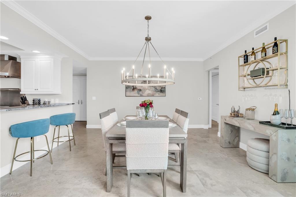 Dining area with a chandelier and ornamental molding