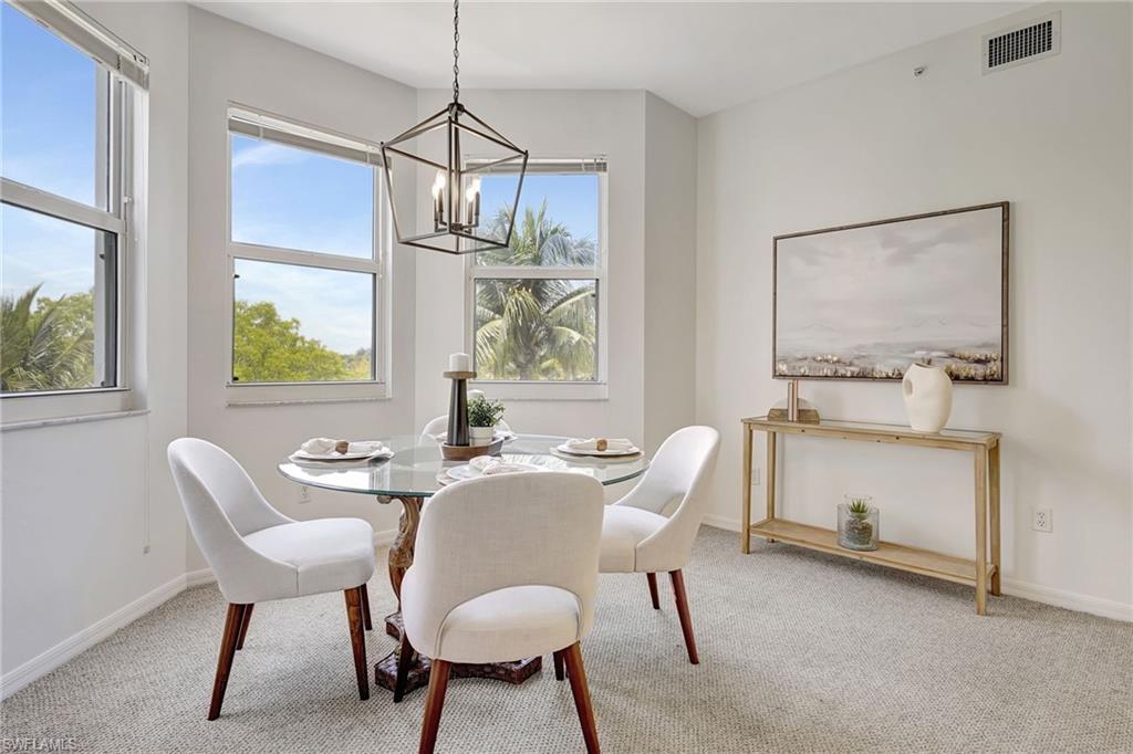 Dining space with carpet floors and an inviting chandelier
