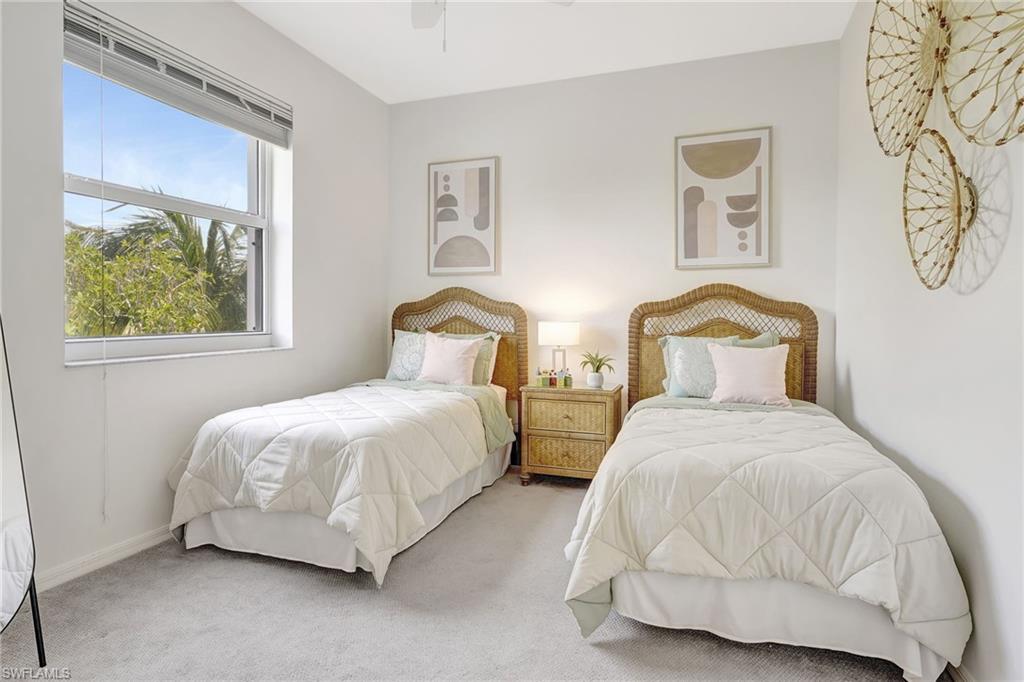 Bedroom with ceiling fan and light colored carpet