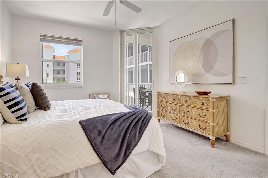 Carpeted bedroom with ceiling fan and access to exterior