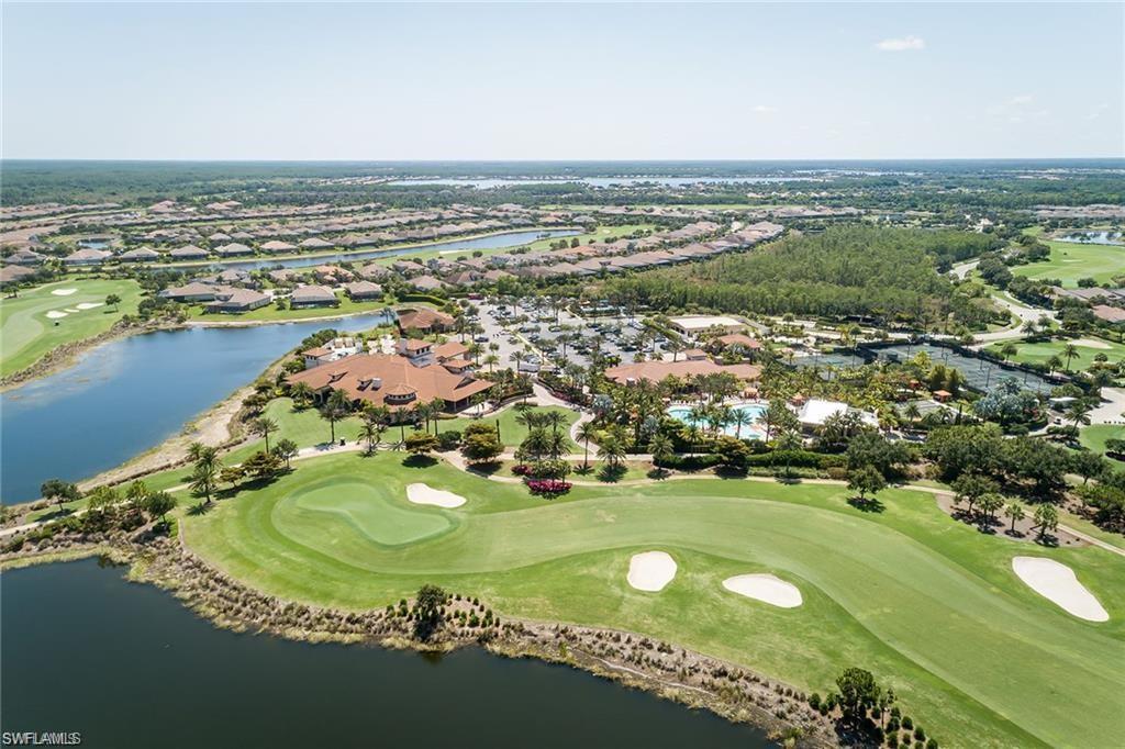 Aerial view of property's location with a golf course, a large body of water, and nearby suburban area