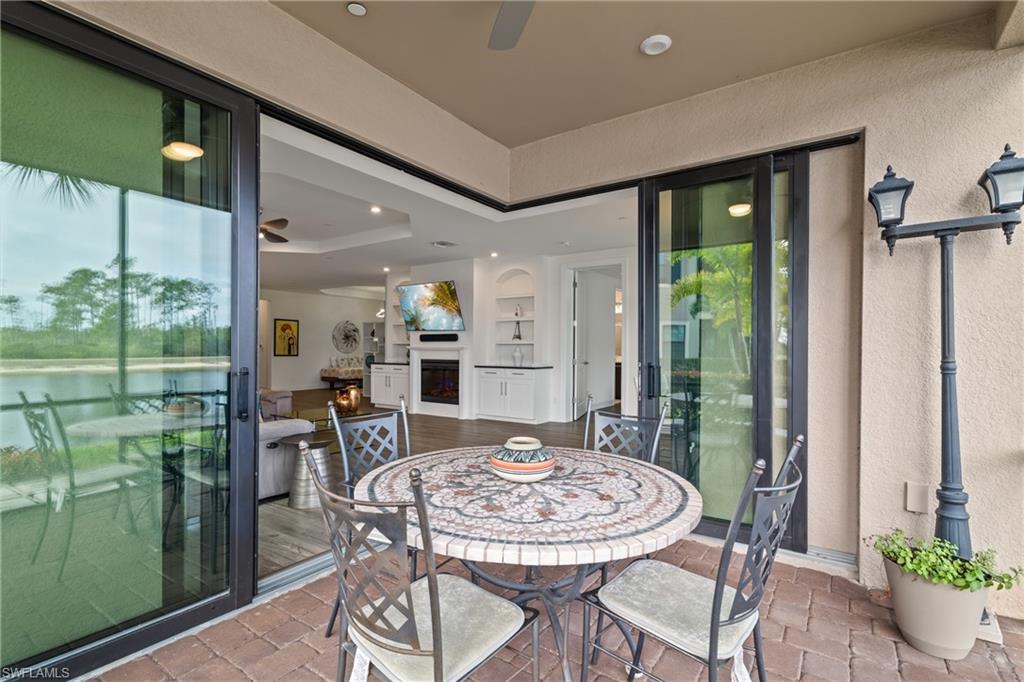 View of patio / terrace featuring ceiling fan, a water view, and outdoor dining space