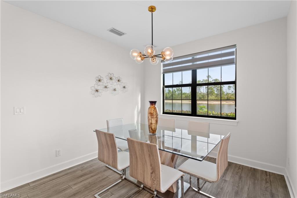 Unfurnished dining area featuring light wood-style flooring, a chandelier, and a water view