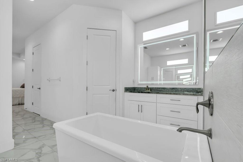 Freestanding soaking tub with dark bronze fixtures