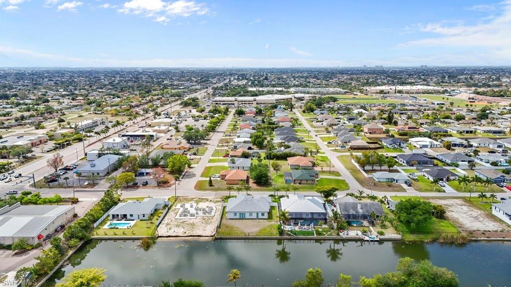 Waterfront property featuring a canal, residential homes, and commercial buildings