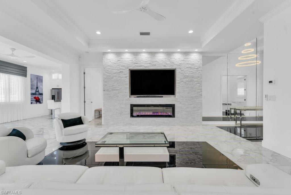 Living area featuring a textured stone-clad media wall with an integrated electric fireplace