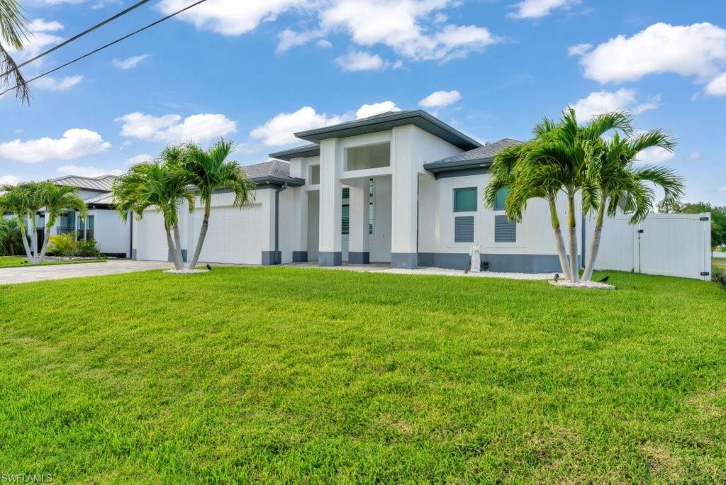 Contemporary exterior featuring a white facade with gray accents, a dark gray roof, and prominent pillars