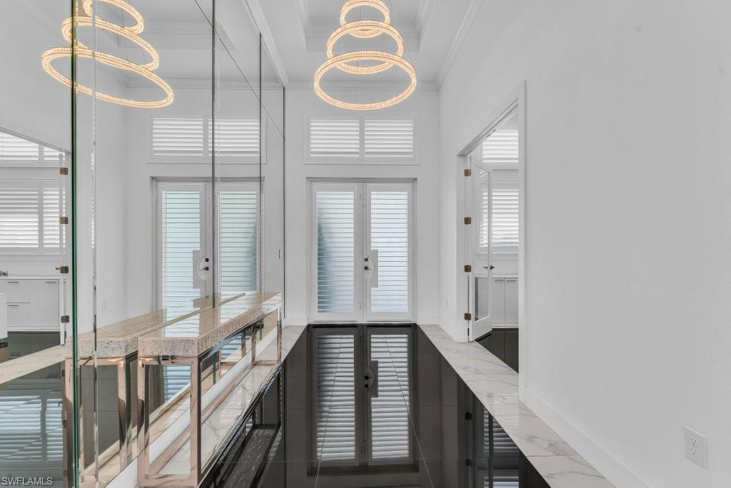 Hallway featuring high-gloss black tile flooring, white walls, and a coffered ceiling