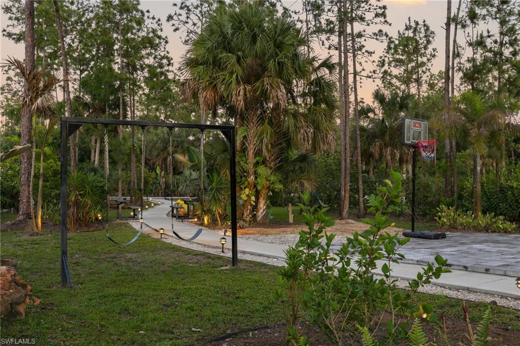 Children's playground with paved basketball court area, a paved and lighted pathway