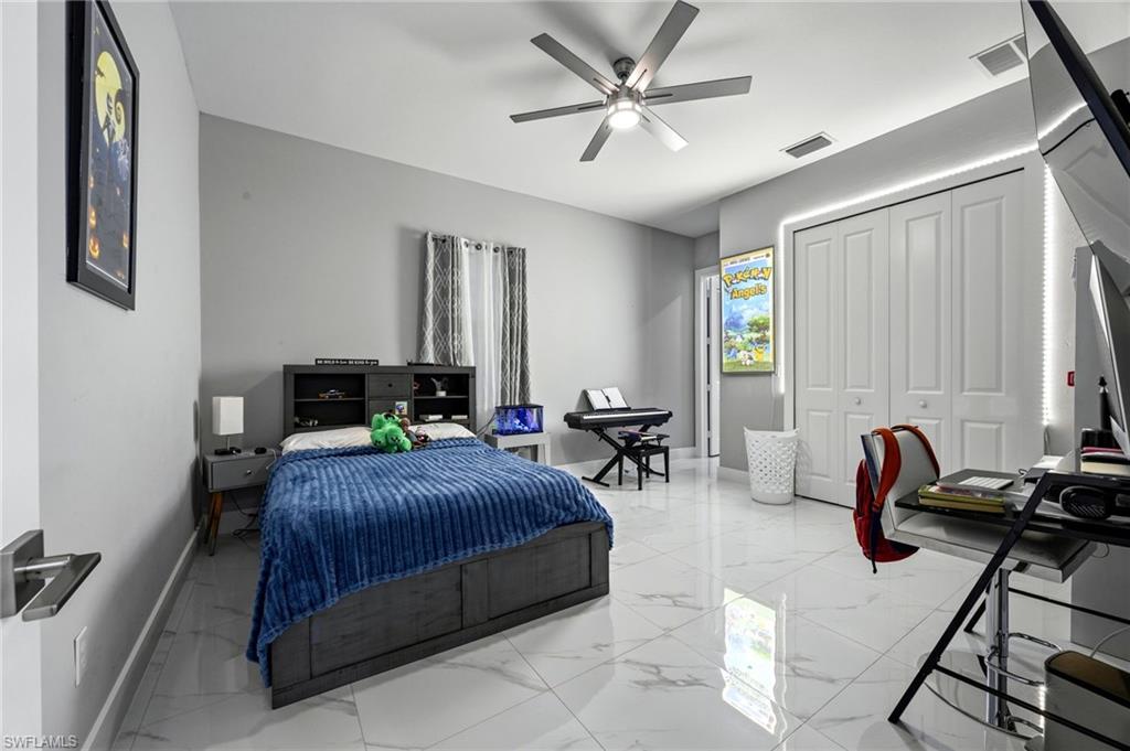 Spacious room featuring large format tile flooring, a contemporary ceiling fan and bi-fold closet doors